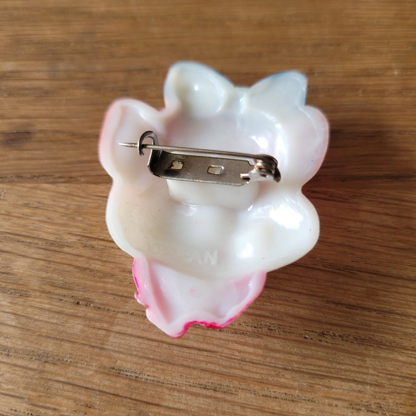 1960s Japanese novelty plastic pig brooch with blue bow