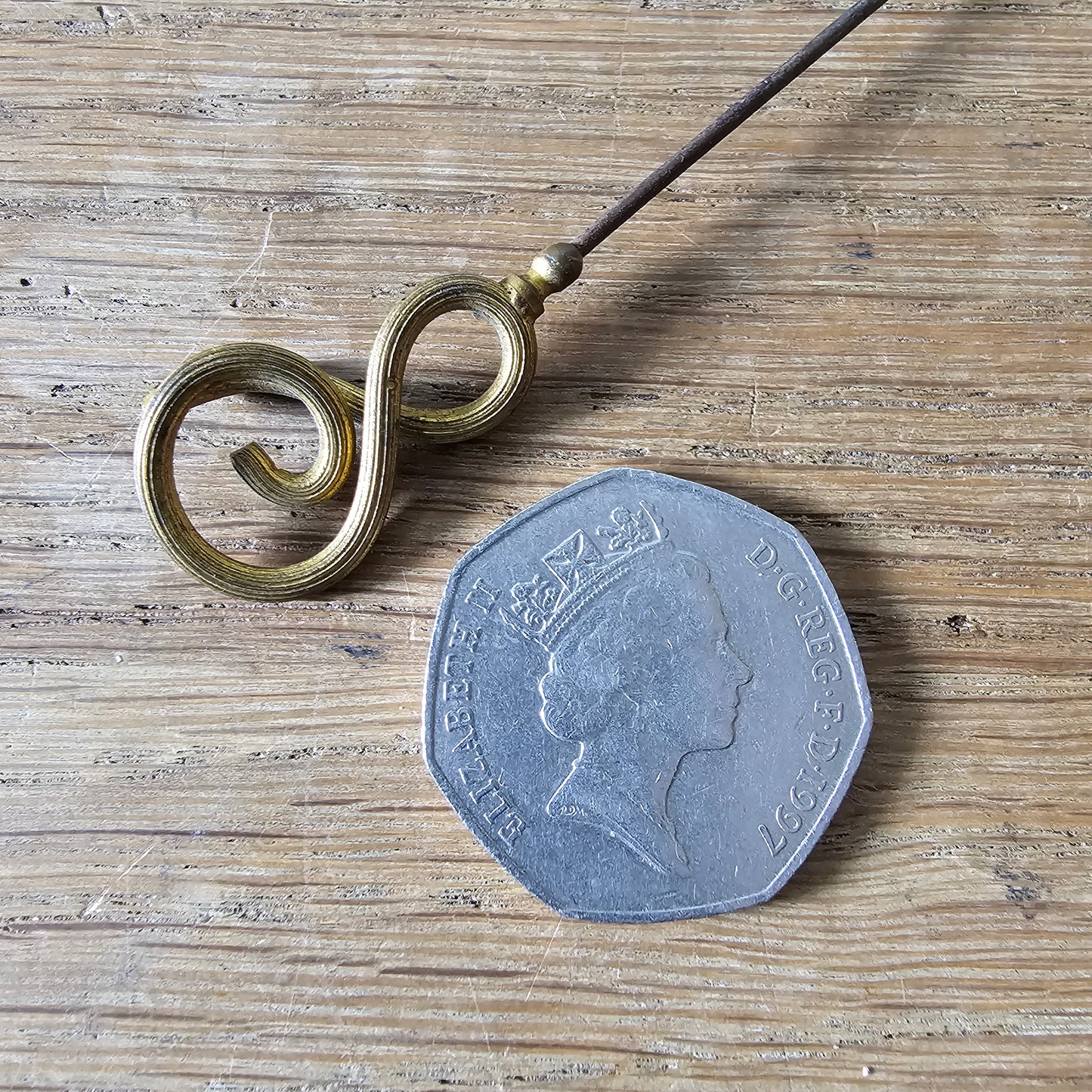 Early 20th century brass scrollwork hat pin