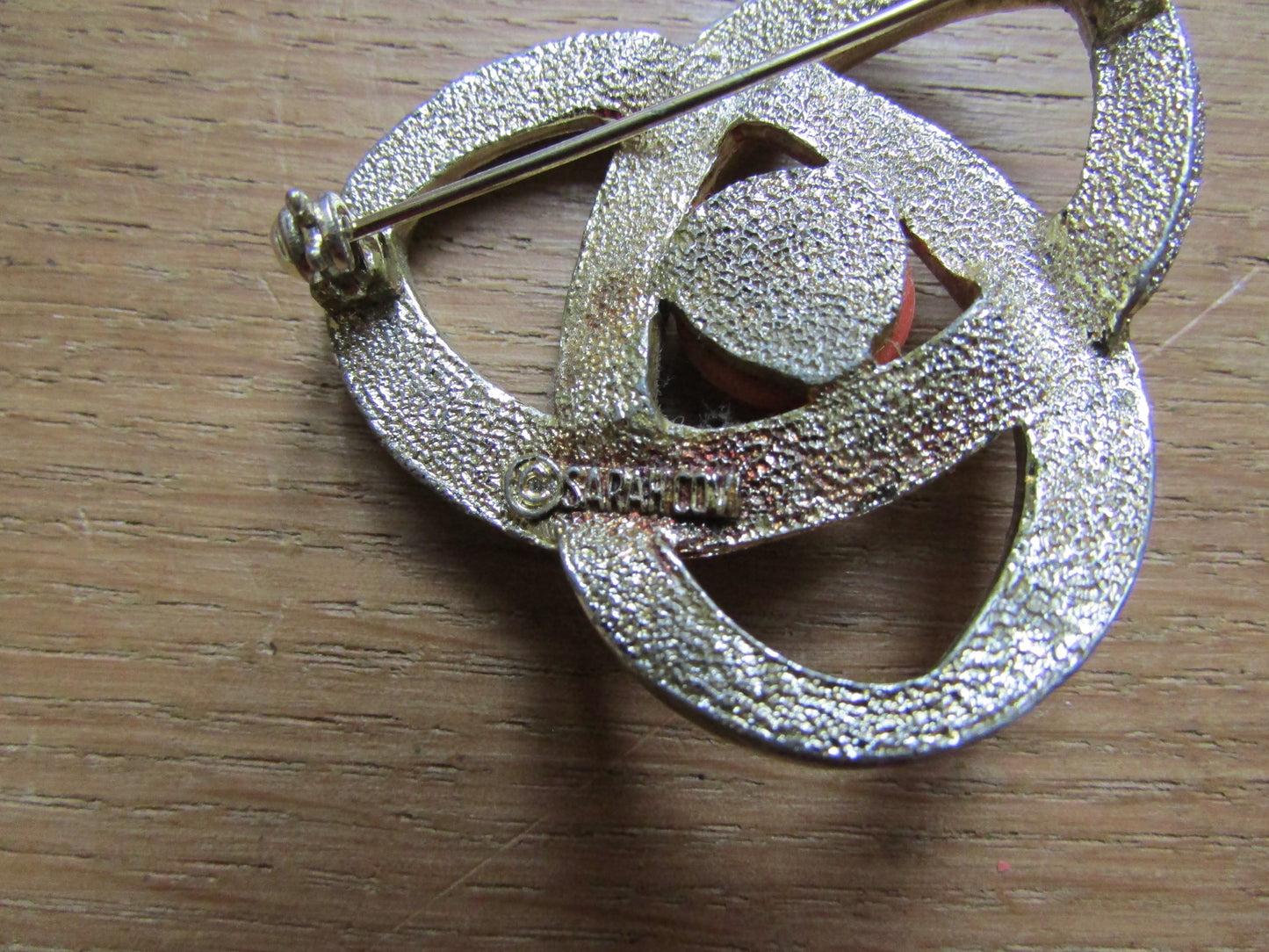 Vintage Sarah Coventry gold-tone twist brooch with tangerine cabochon centre