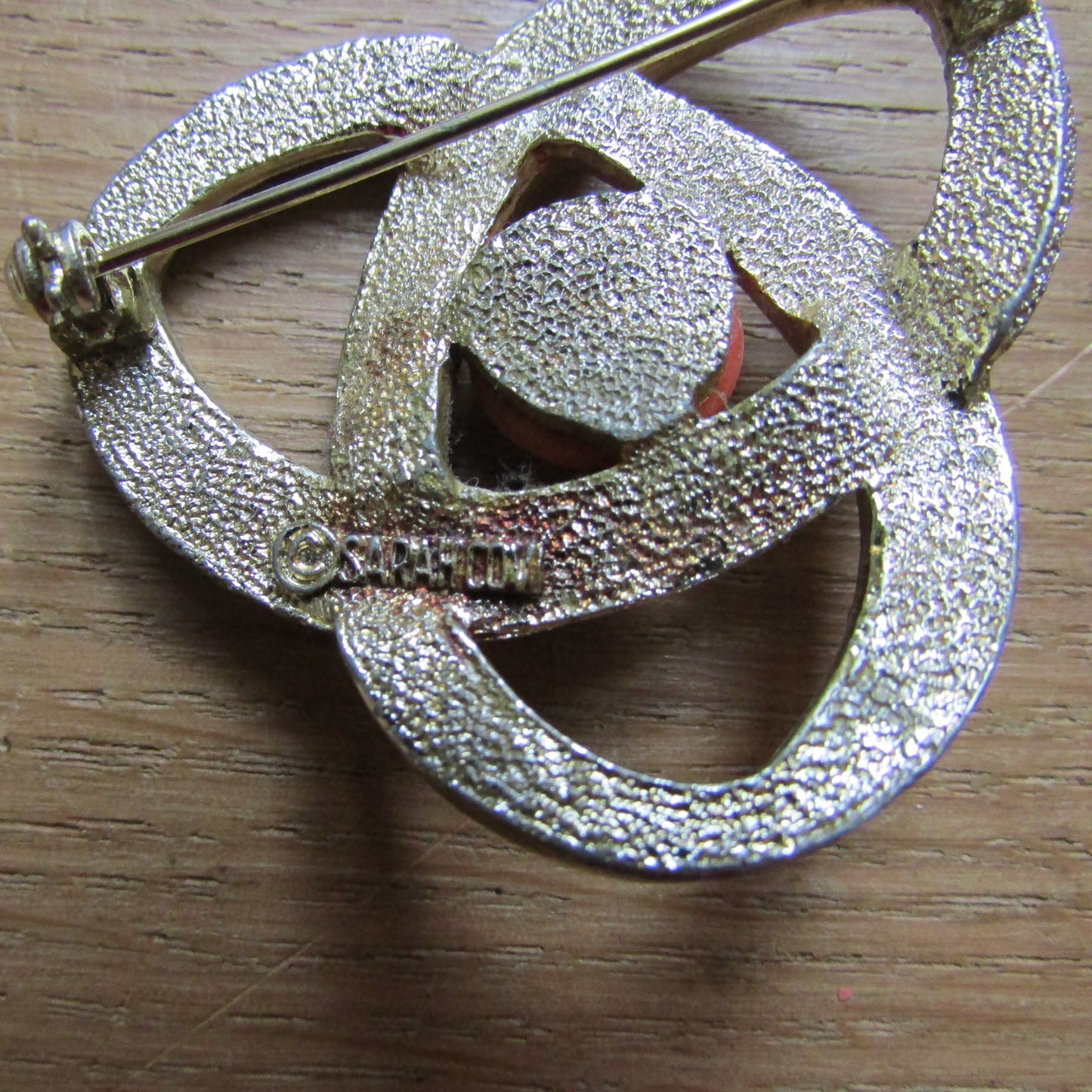 Vintage Sarah Coventry gold-tone orbit brooch with tangerine cabochon centre