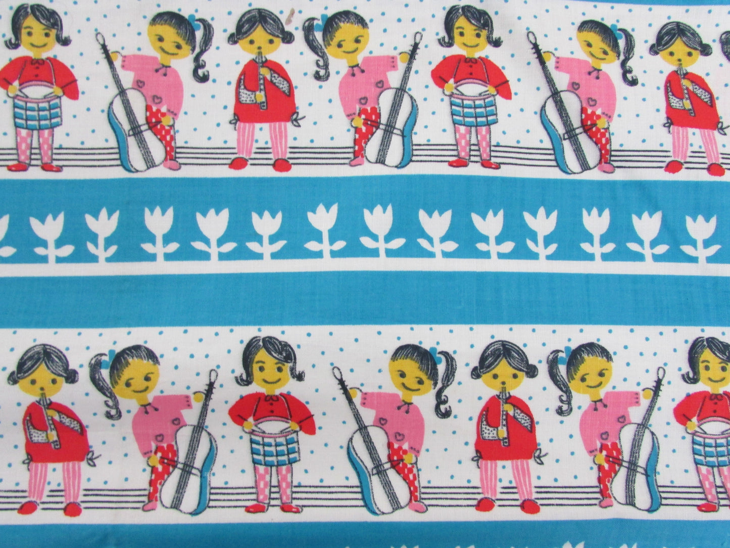 Home-made vintage-style nursery cushion cover depicting pony-tailed girls playing musical instruments, with contrast white reverse