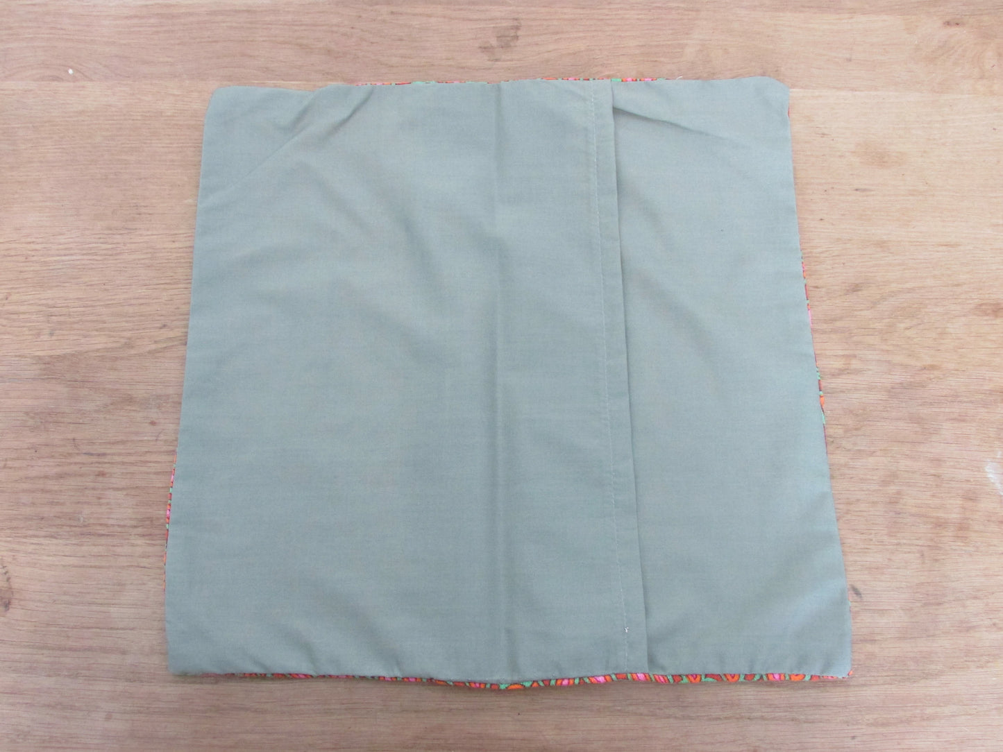Home-made 1970s orange/pink/green pattern cushion cover with contrast green reverse