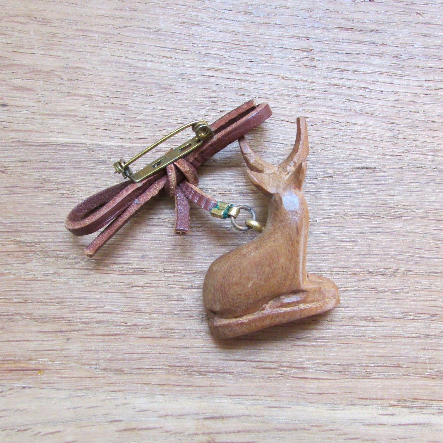 1960s/70s hand carved wooden sitting antelope brooch with leather bow