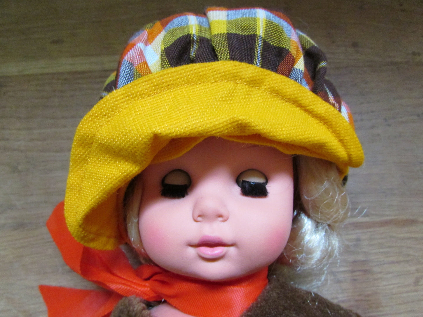 1970s plastic sleepy eye doll in cool tartan coat and matching hat