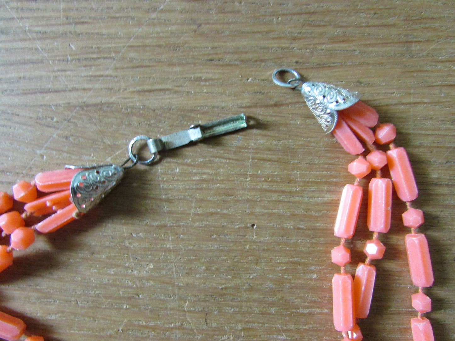 Mid-century fused plastic "dot n dash" coral bead triple strand necklace, silver-tone clasp detail