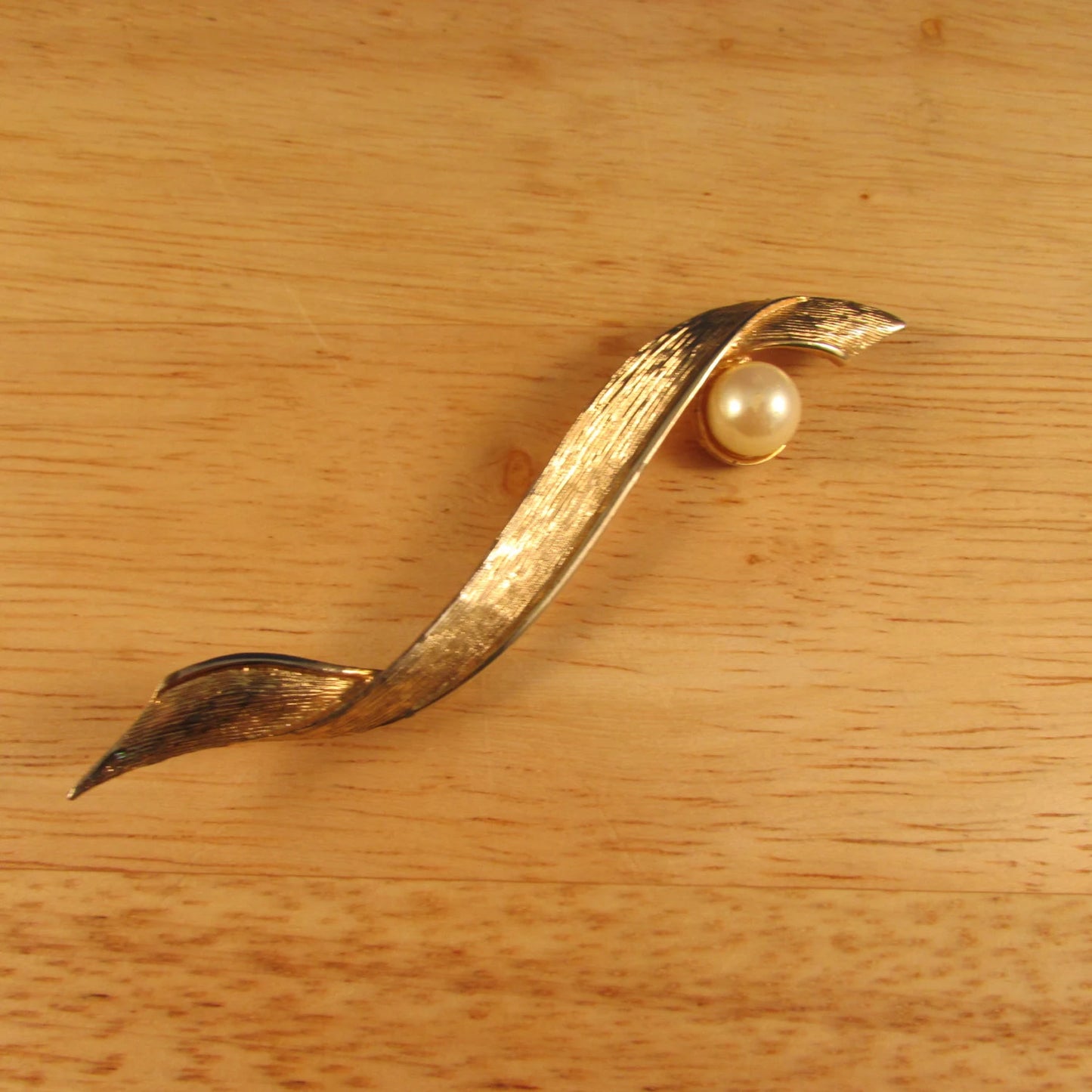 Large vintage gold-tone ribbon brooch with faux pearl