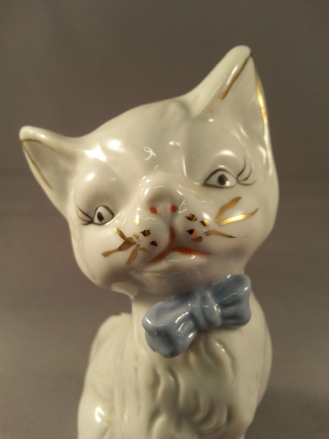 circa. 1960s kitsch white kitten ornament with blue bow