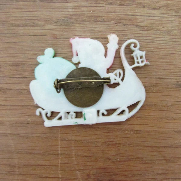 Kitsch home-made brooch using vintage plastic Santa in sleigh cake topper