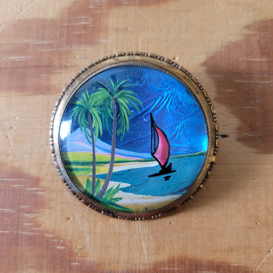 Vintage gold-tone painted butterfly wing brooch/pendant, detailing sailing boat & palm tree