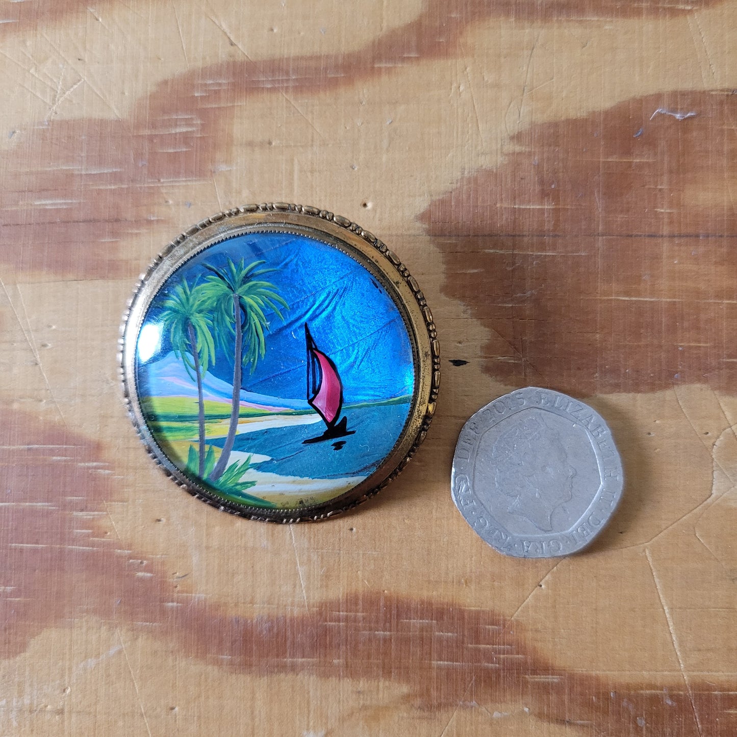 Vintage gold-tone painted butterfly wing brooch/pendant, detailing sailing boat & palm tree