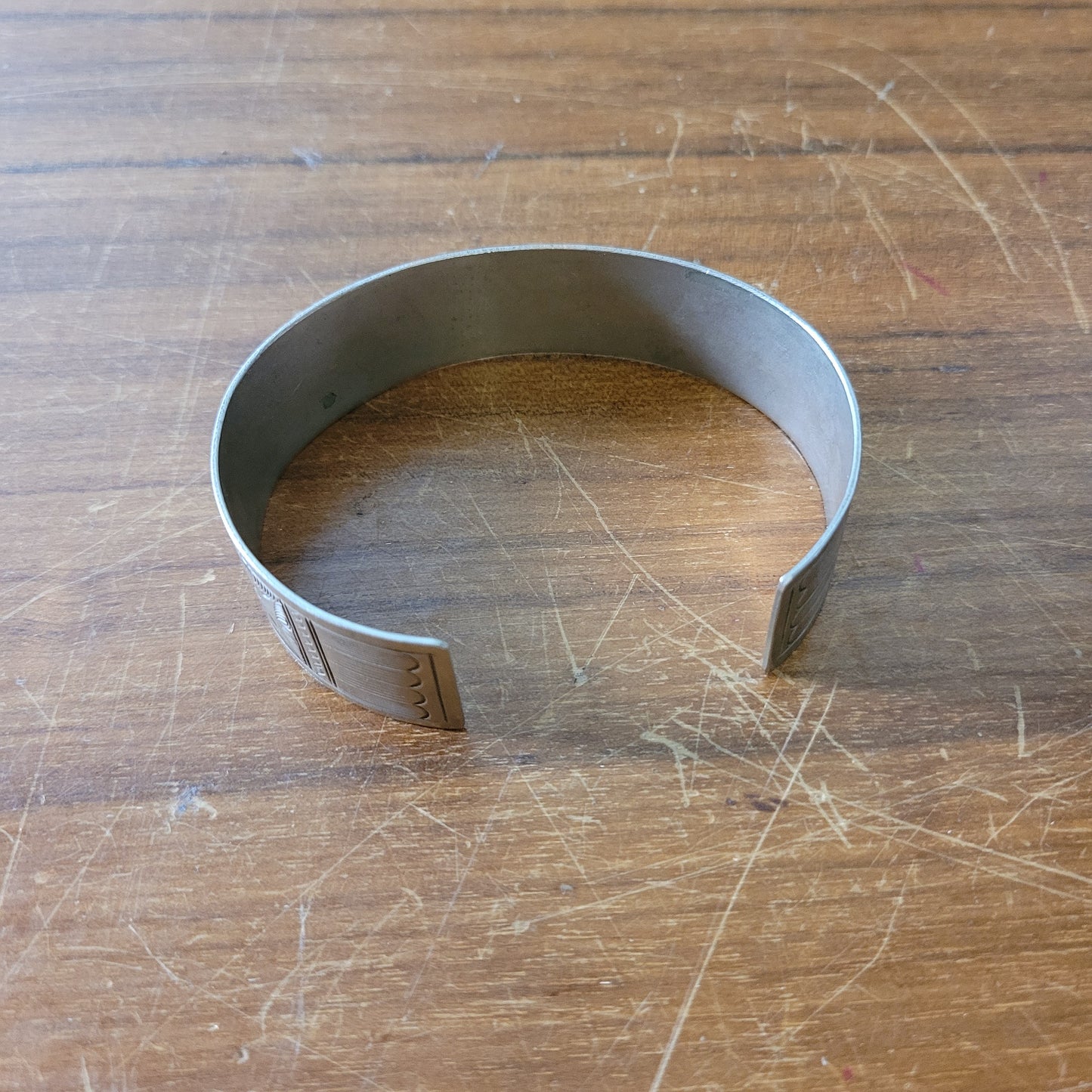 Mid-century engraved silver tone cuff bracelet with bird and foliate design