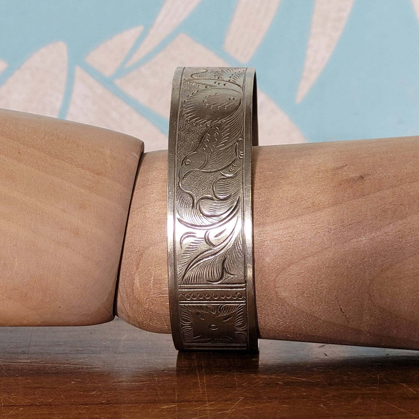 Mid-century engraved silver tone cuff bracelet with bird and foliate design