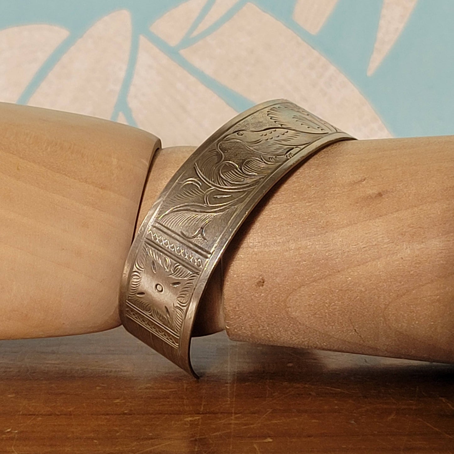 Mid-century engraved silver tone cuff bracelet with bird and foliate design