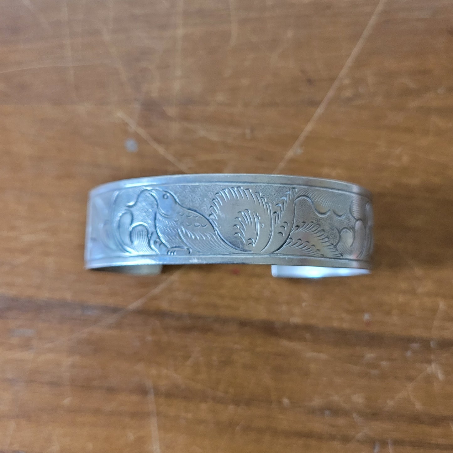 Mid-century engraved silver tone cuff bracelet with bird and foliate design