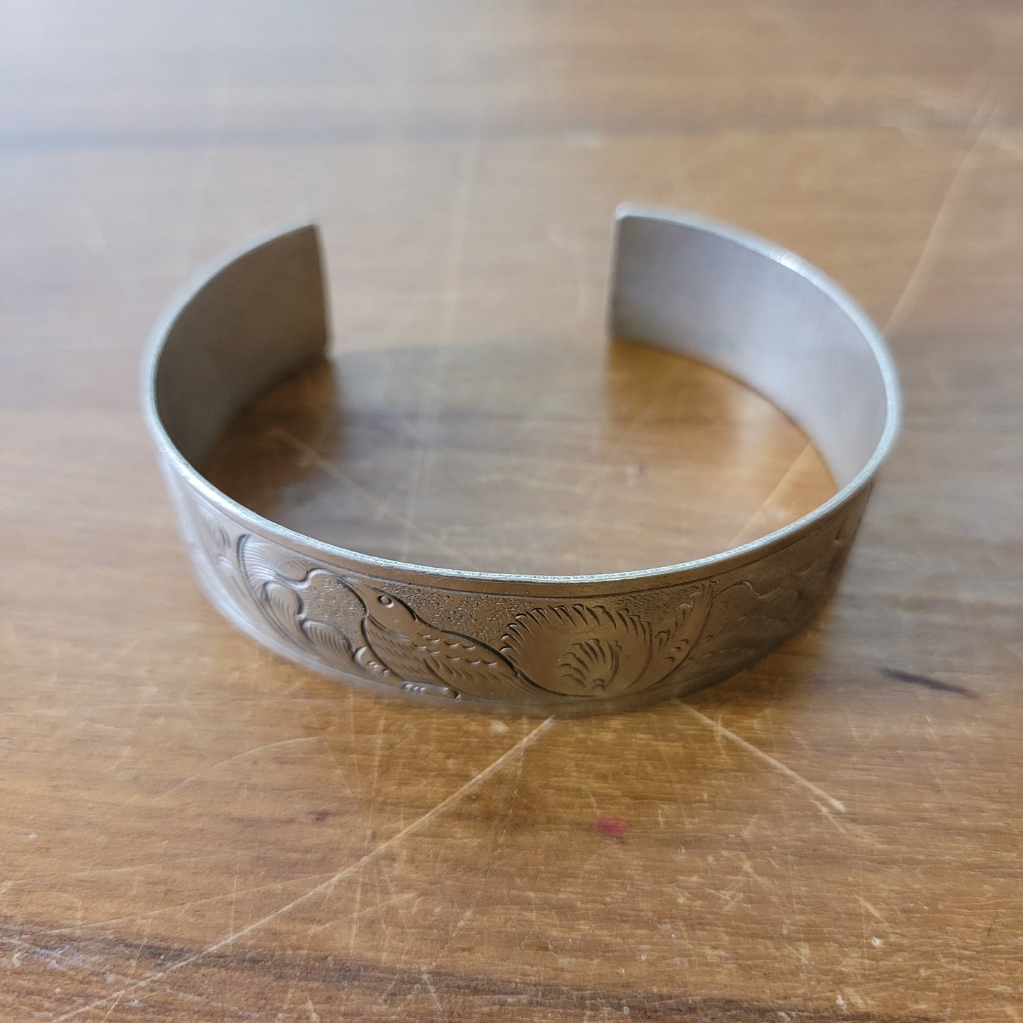 Mid-century engraved silver tone cuff bracelet with bird and foliate design