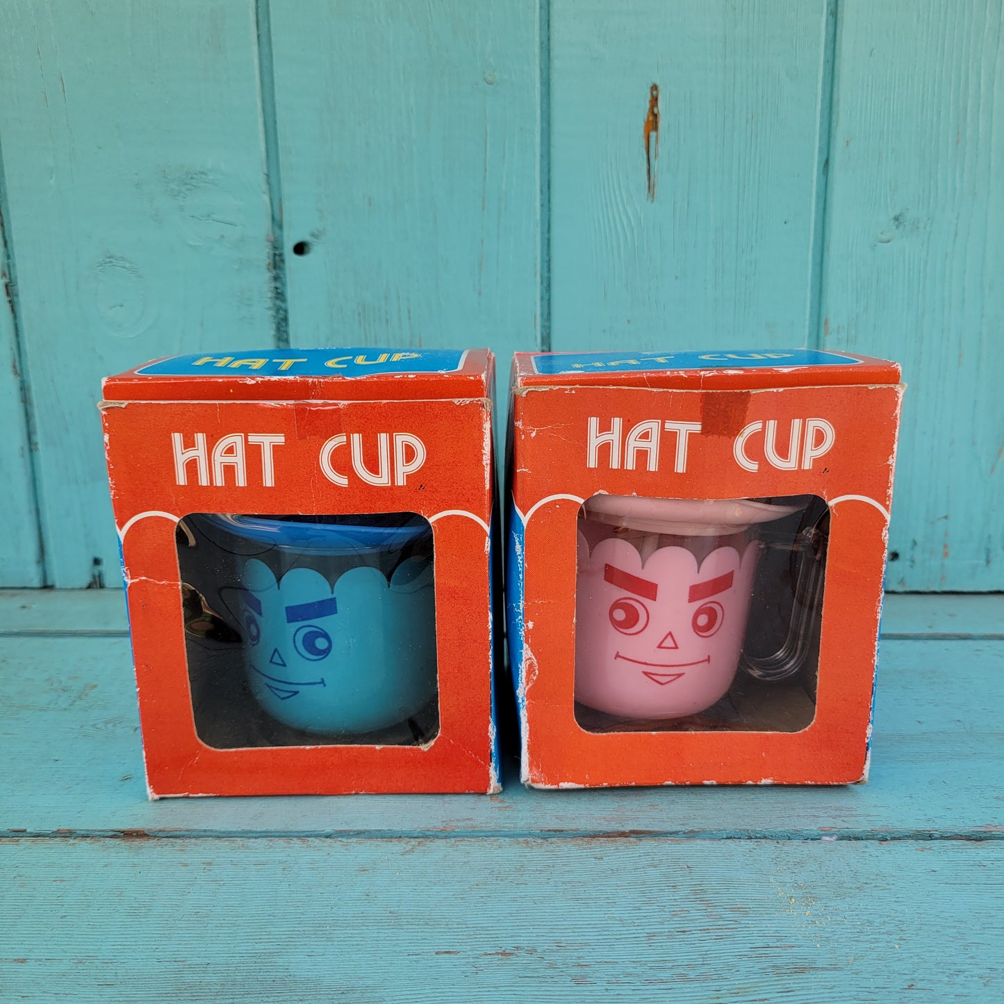 Two vintage plastic 'Hat' cups, with original packaging, in pink & blue