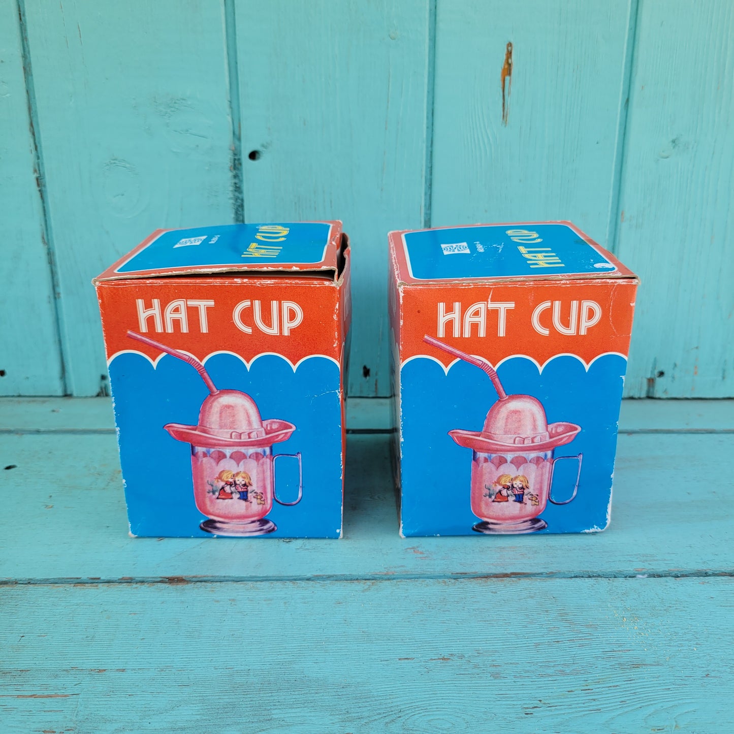 Two vintage plastic 'Hat' cups, with original packaging, in pink & blue