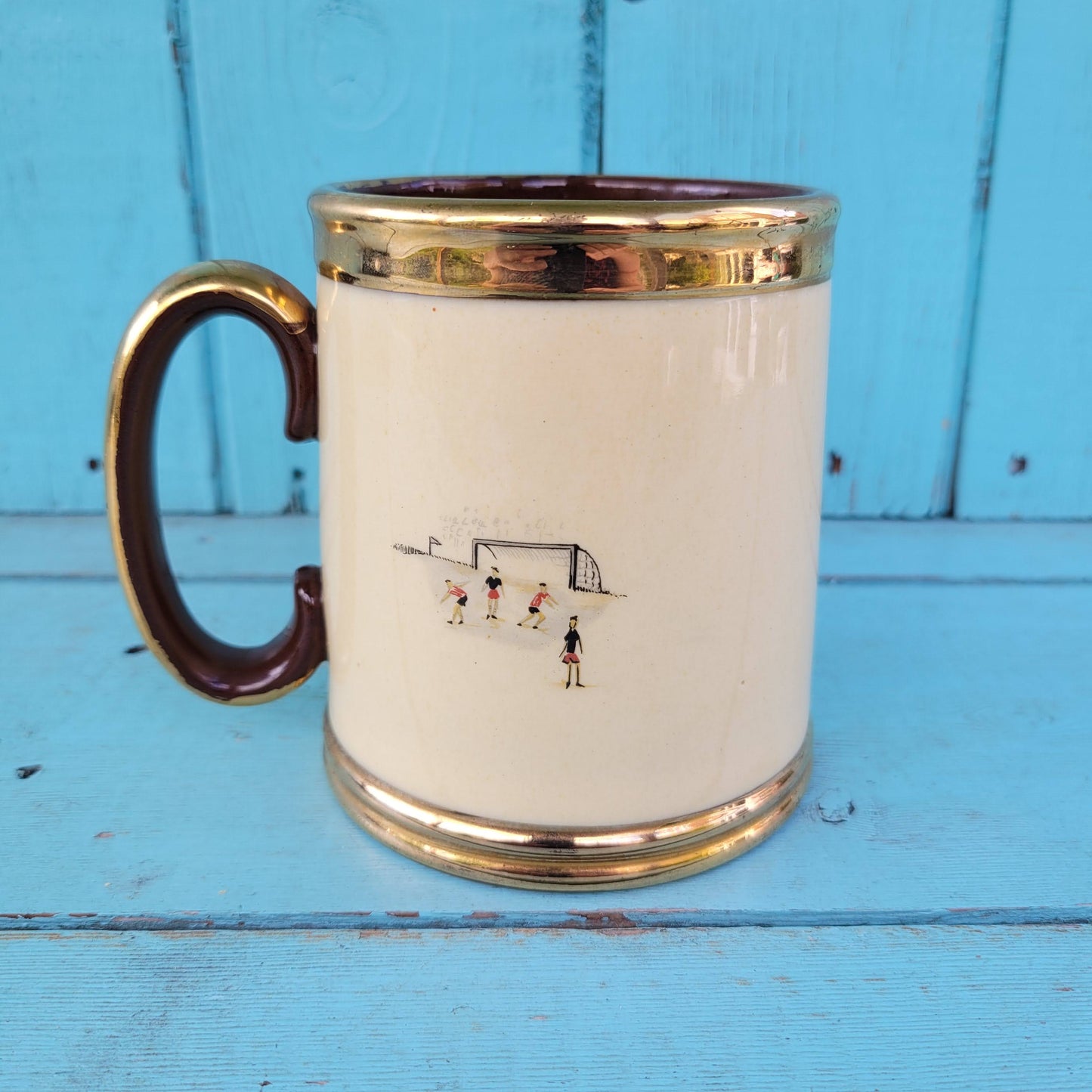Collectable 1950s Gibsons china tankard with copper gilt edging and football players motif