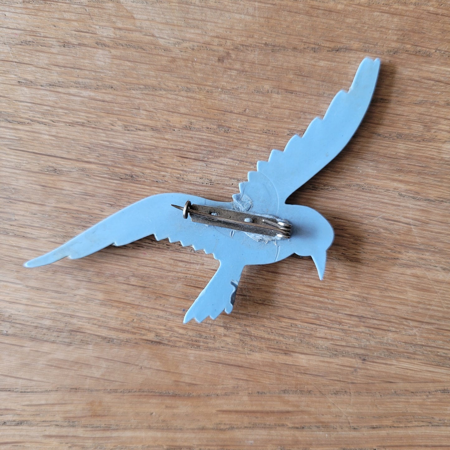 circa. 1930s pale blue celluloid flying bird brooch