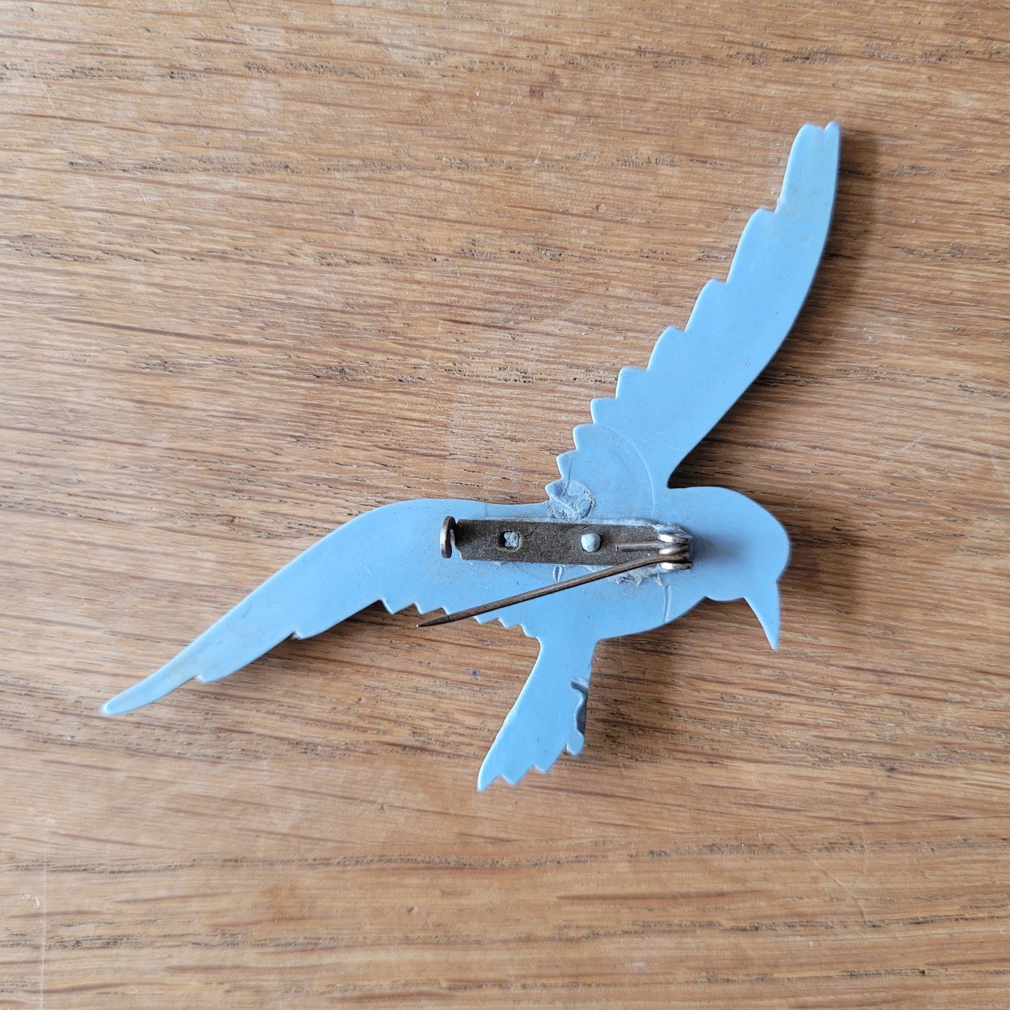 circa. 1930s pale blue celluloid flying bird brooch