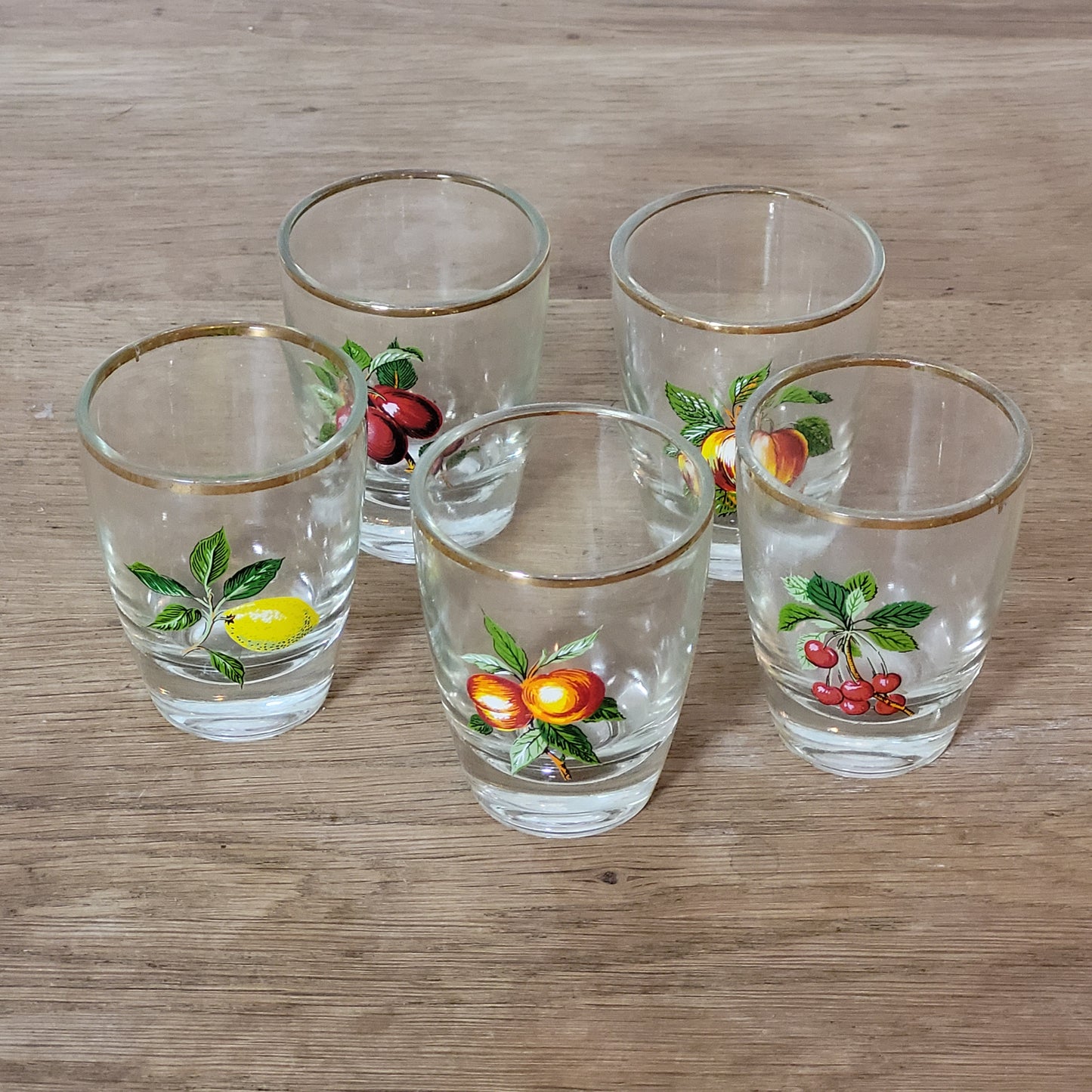 Set of five 1970s fruit patterned shot glasses with gilt trim
