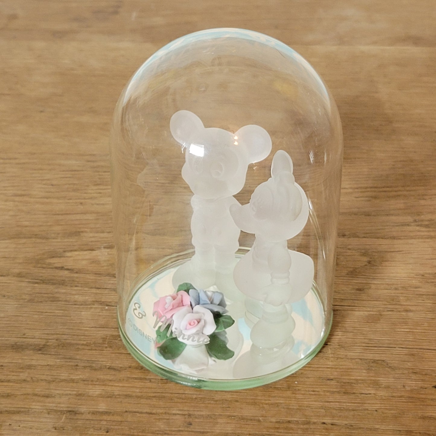 Collectable Disney frosted glass Minnie & Mickey Mouse figurines displayed under glass cloche