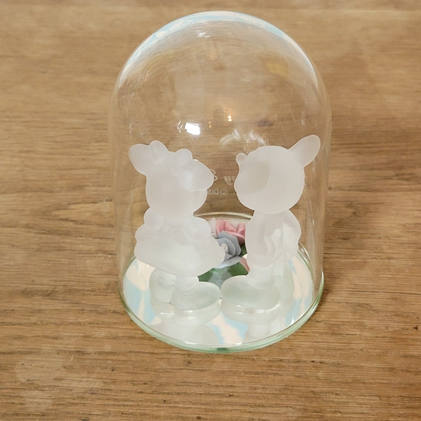 Collectable Disney frosted glass Minnie & Mickey Mouse figurines displayed under glass cloche