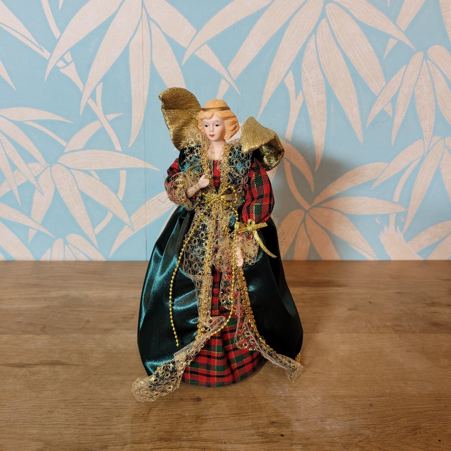 Vintage angel tree topper in plaid-sleeved green dress with porcelain face and hands