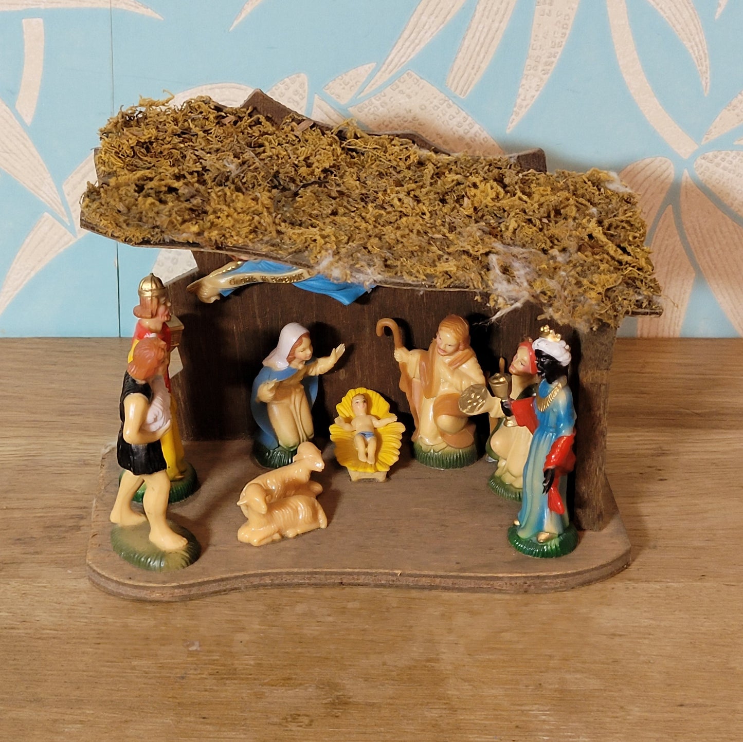 Vintage traditional nativity scene with plastic figures in wooden stable