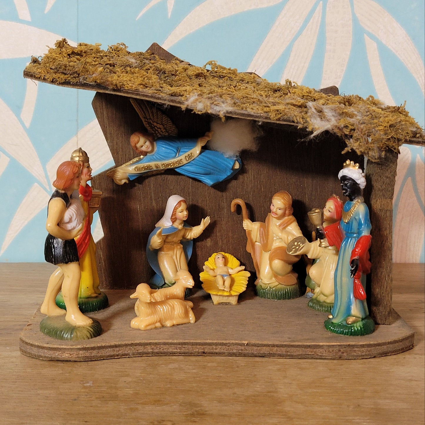 Vintage traditional nativity scene with plastic figures in wooden stable