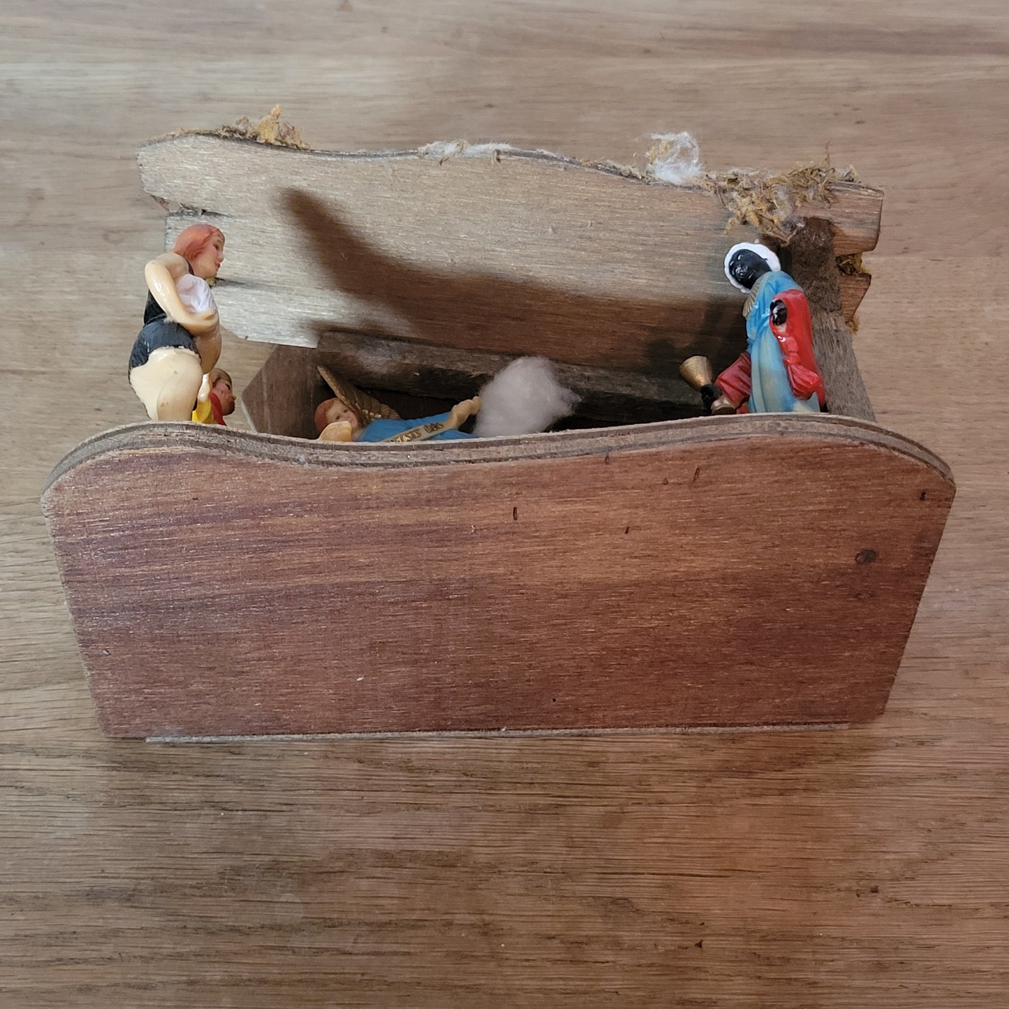 Vintage traditional nativity scene with plastic figures in wooden stable