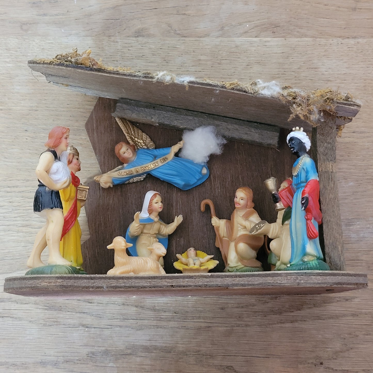 Vintage traditional nativity scene with plastic figures in wooden stable
