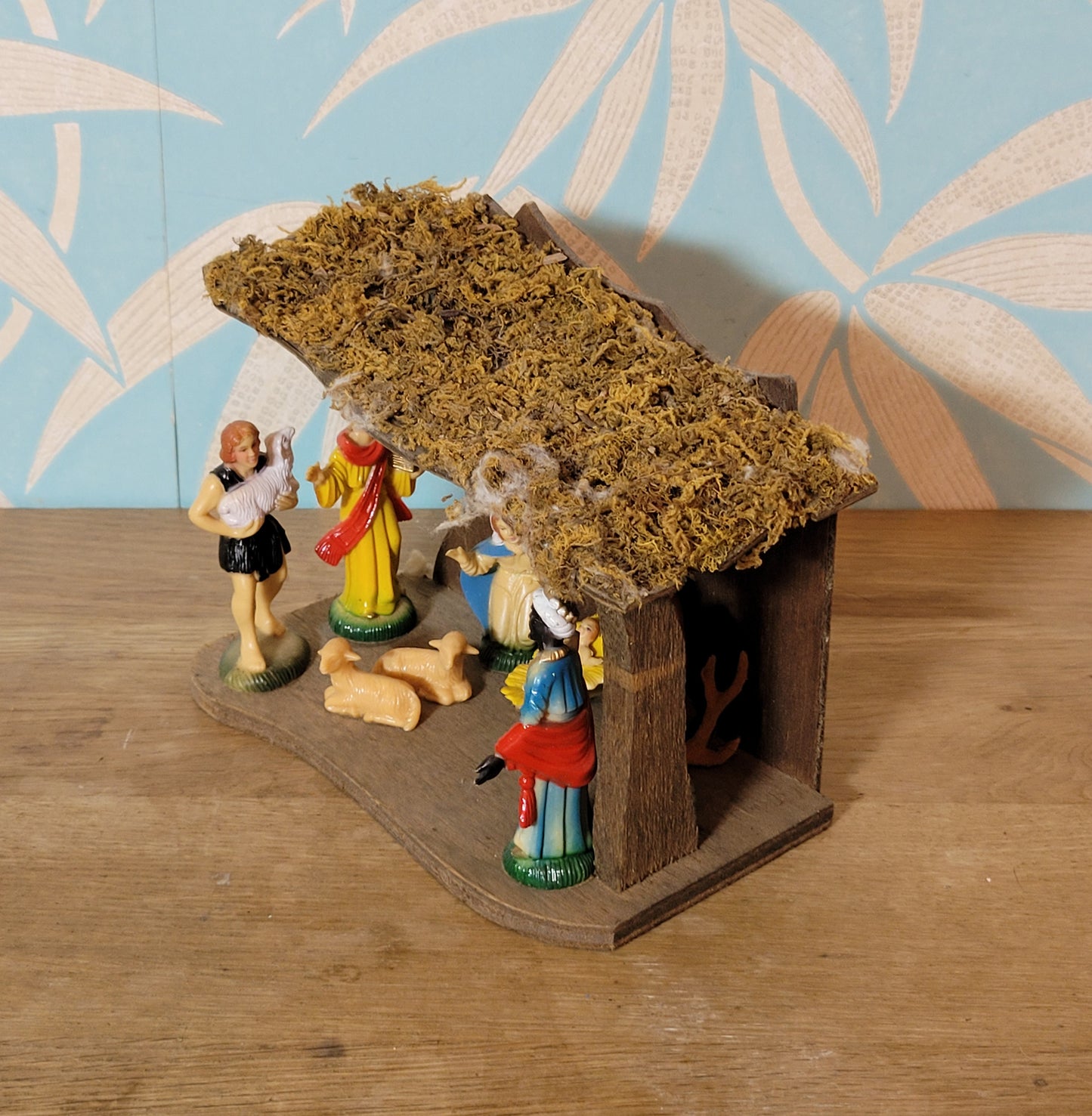 Vintage traditional nativity scene with plastic figures in wooden stable