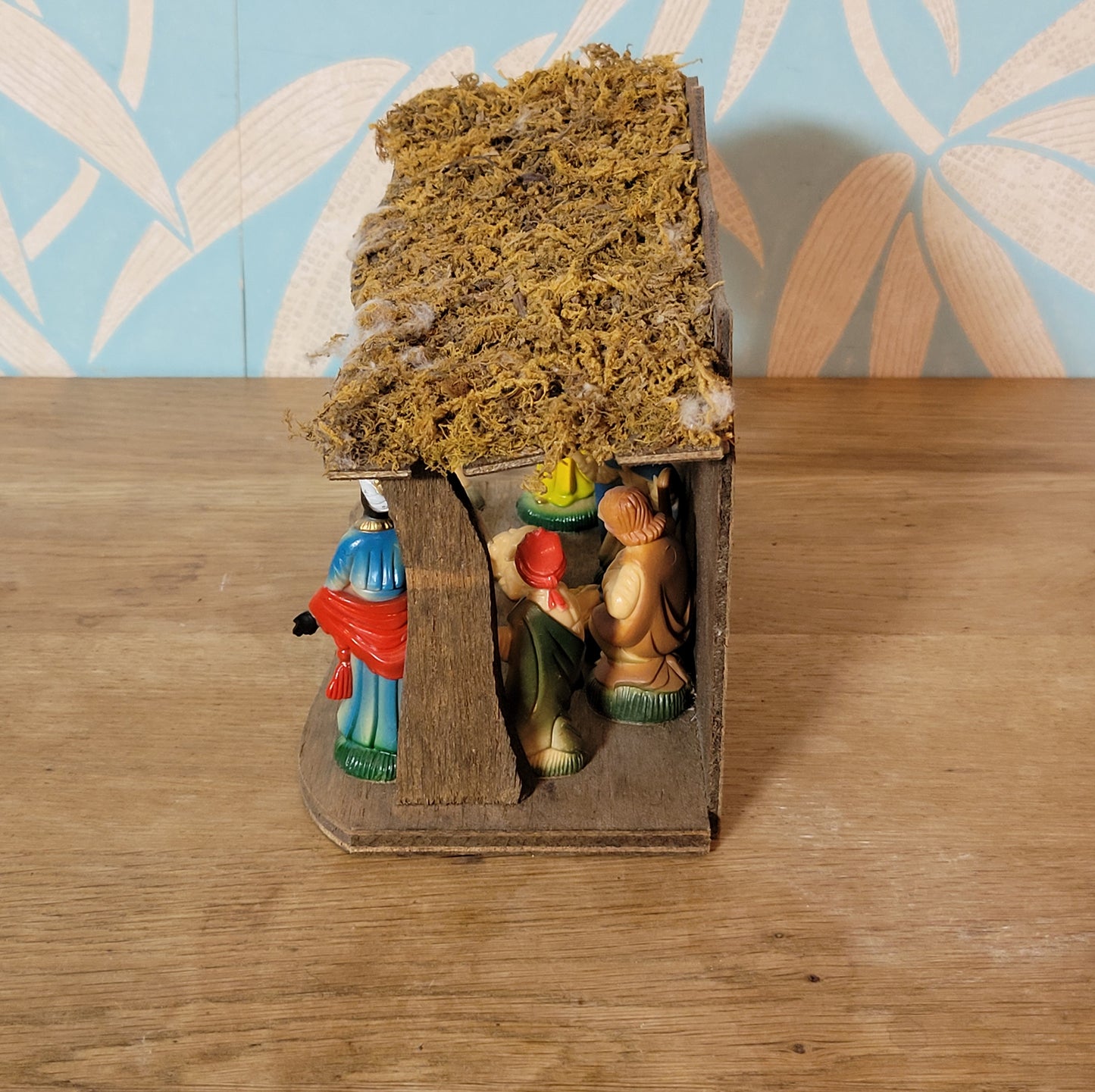 Vintage traditional nativity scene with plastic figures in wooden stable