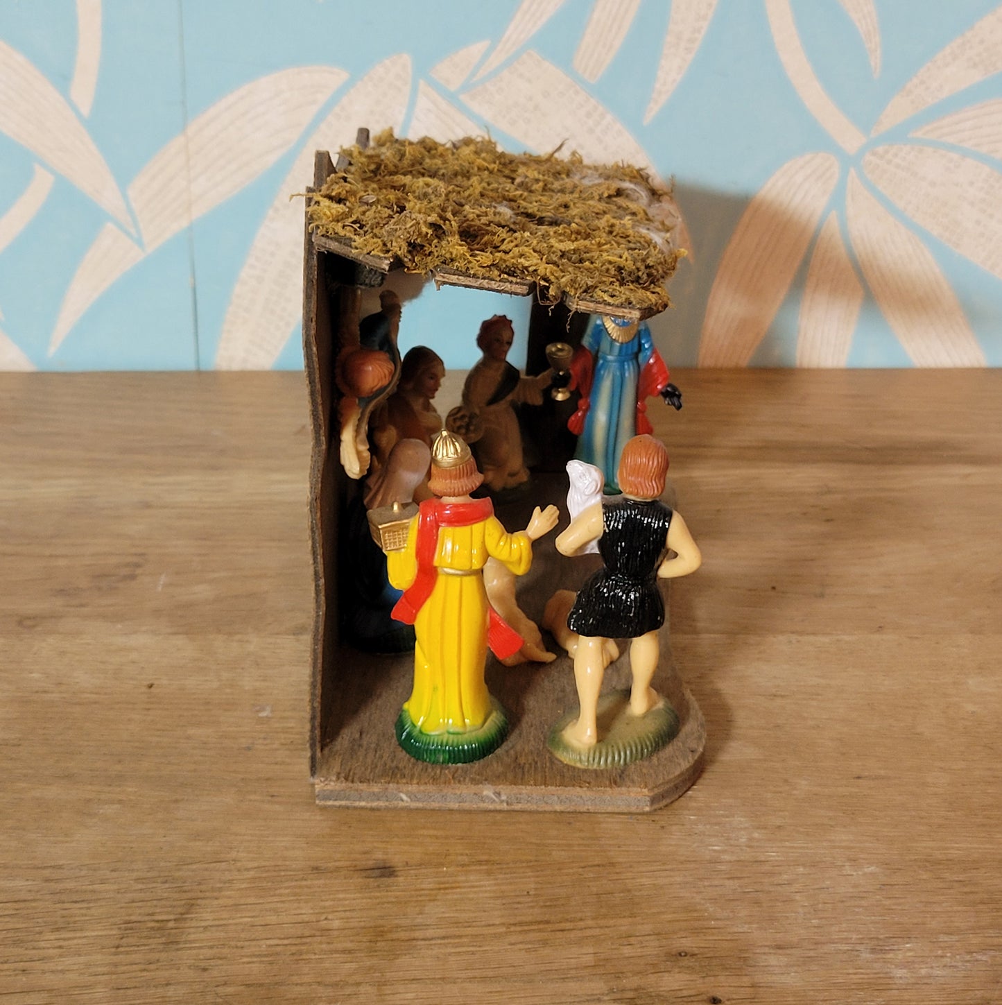 Vintage traditional nativity scene with plastic figures in wooden stable