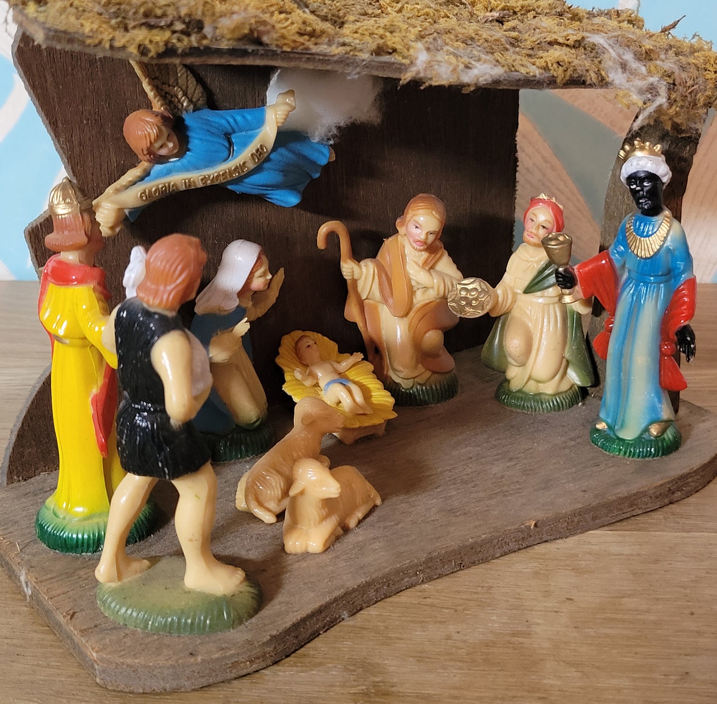Vintage traditional nativity scene with plastic figures in wooden stable