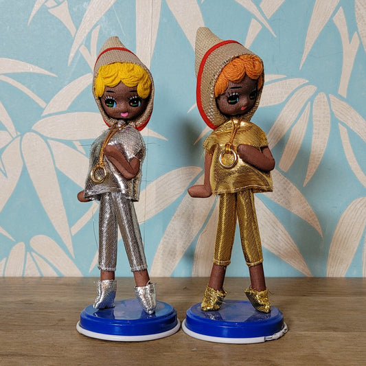 Pair of cute 1960s Bradley big eye pose dolls in co-ordinating metallic silver, & gold outfits