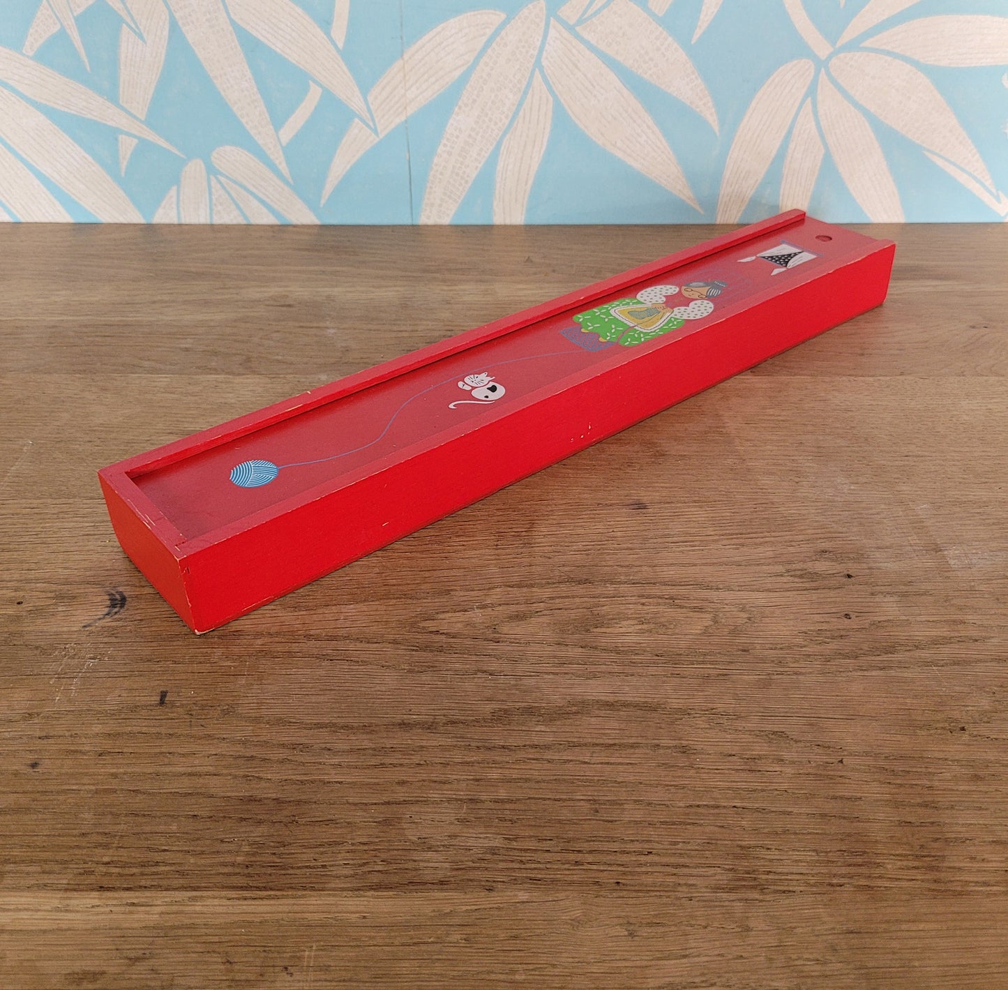1970s red wooden knitting needle box with sliding lid, granny knitting motif