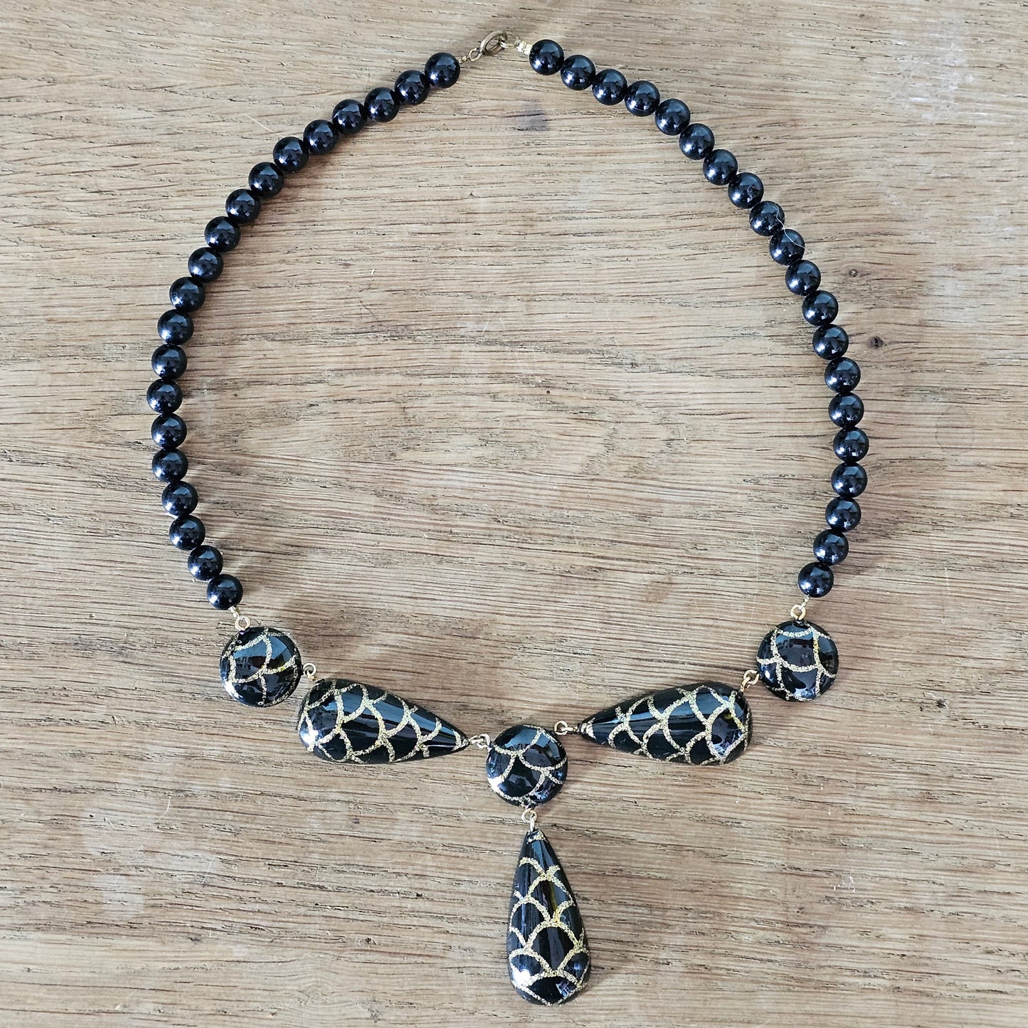 1980s black lucite bead drop necklace with gold glitter pattern detail