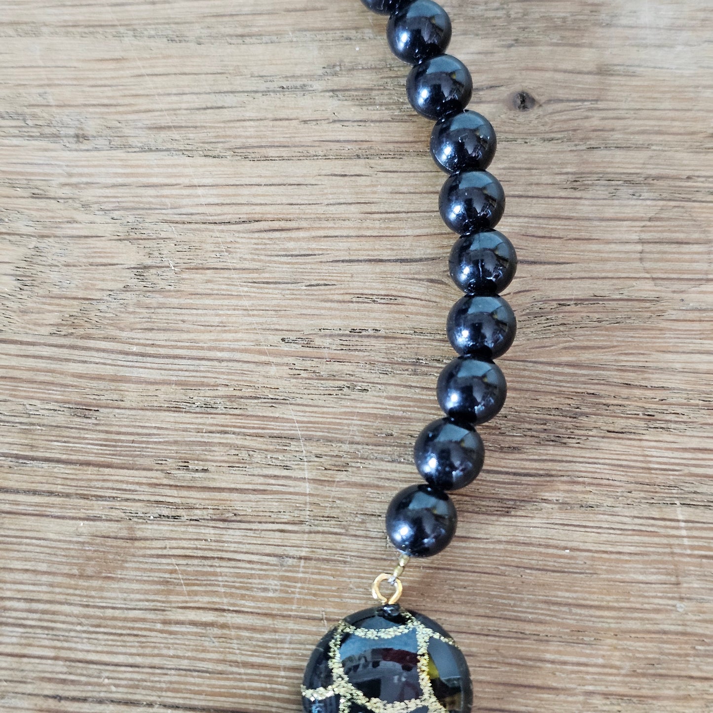 1980s black lucite bead drop necklace with gold glitter pattern detail