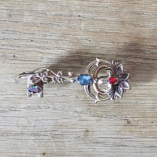 1940s Coro-style scrolled key brooch with coloured rhinestone detail