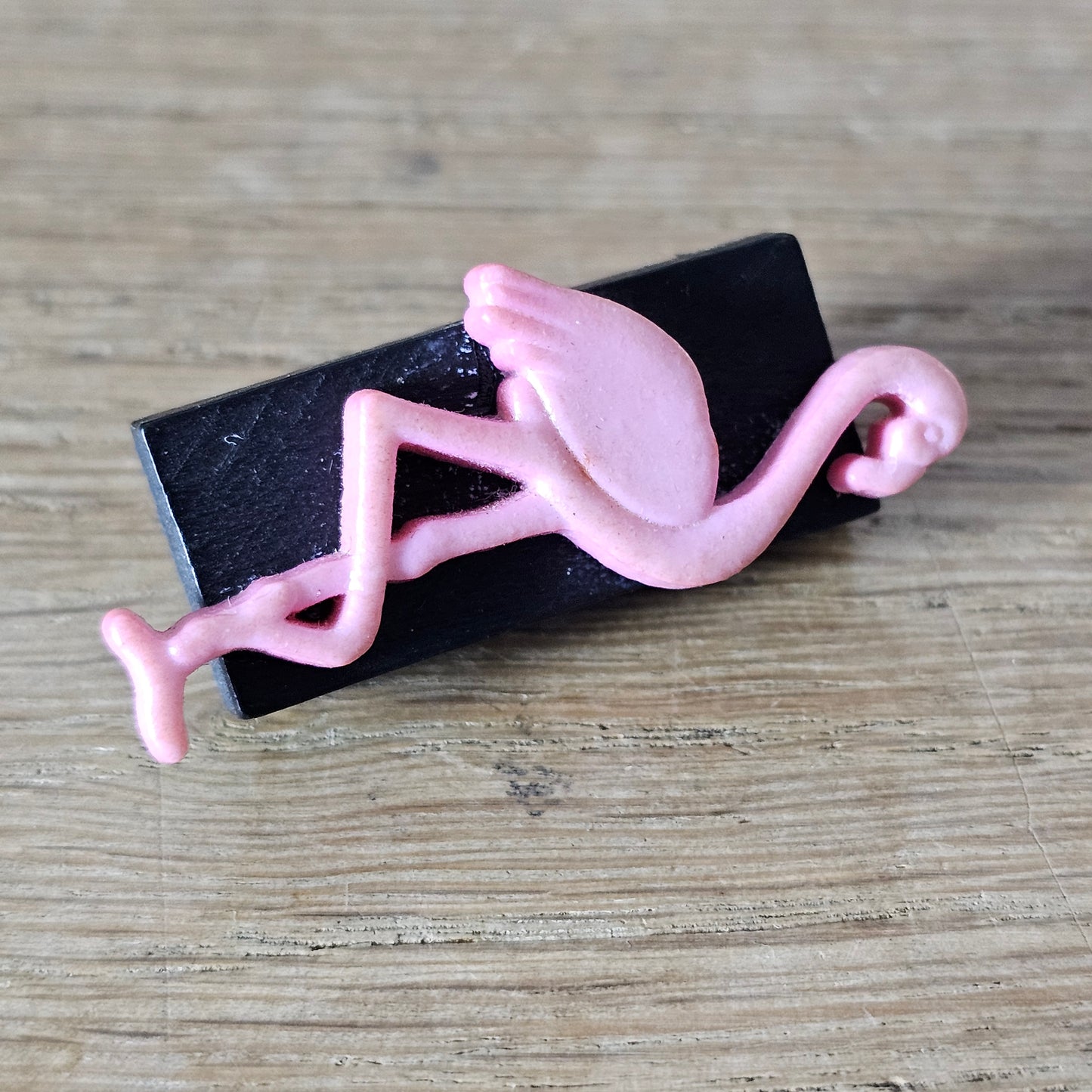 Home-made brooch using pink plastic flamingo on rectangular wooden bead