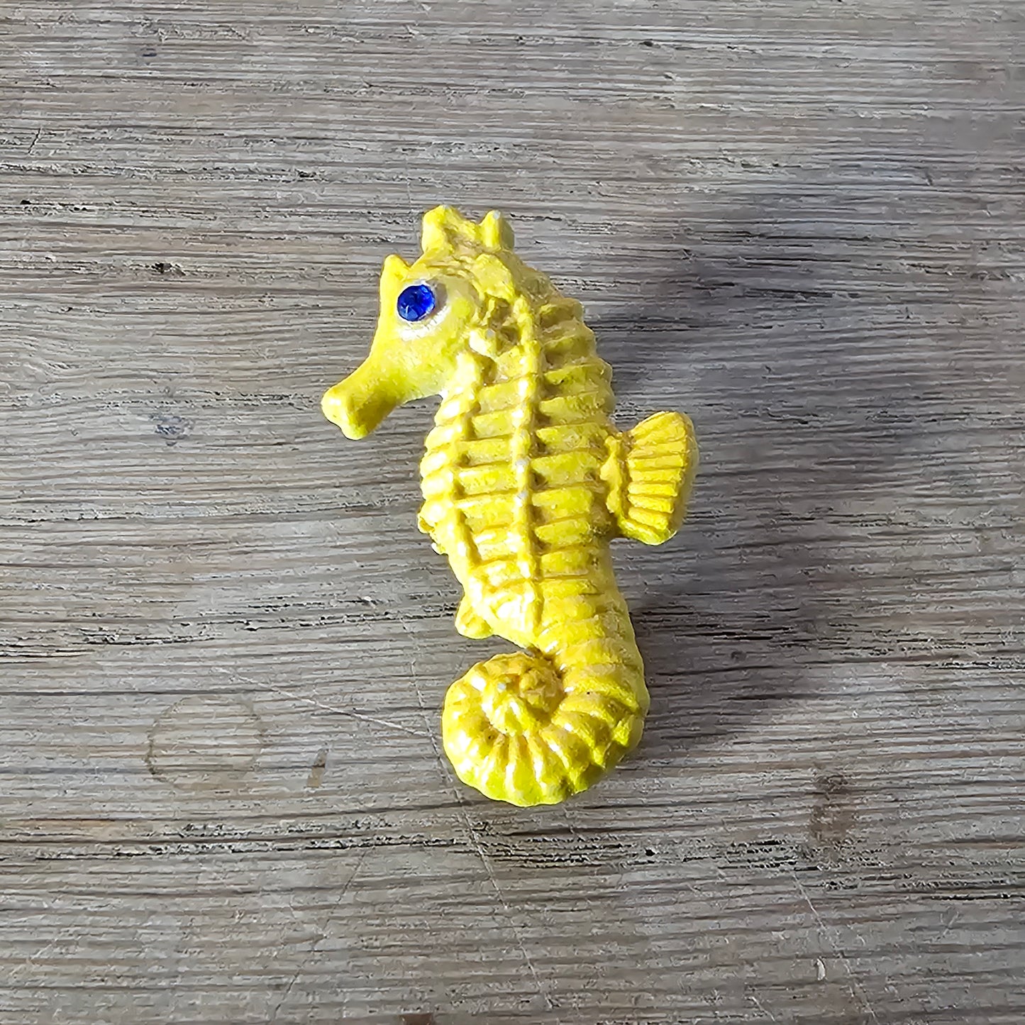 Home-made brooch using yellow celluloid seahorse with added diamante eye