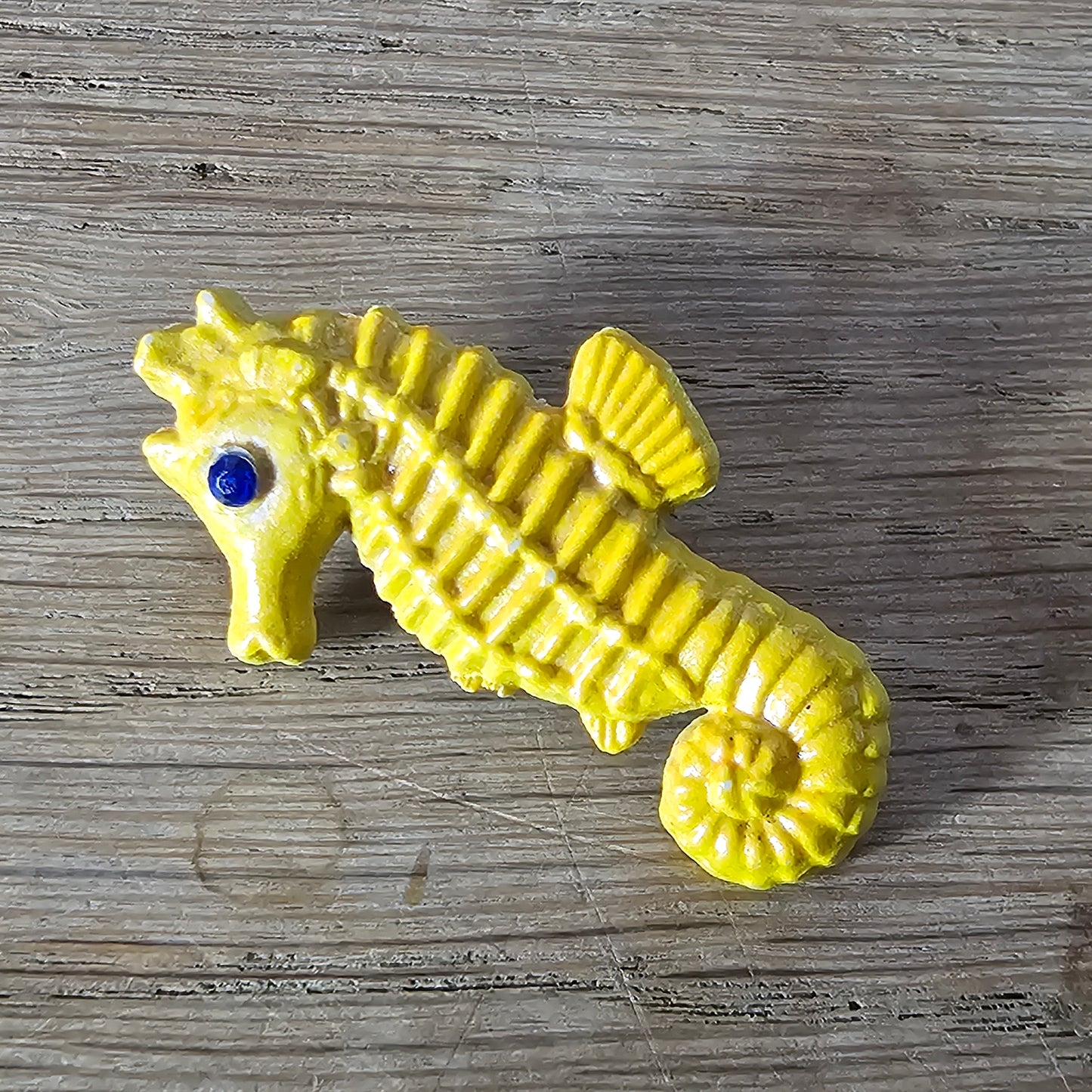 Home-made brooch using yellow celluloid seahorse with added diamante eye