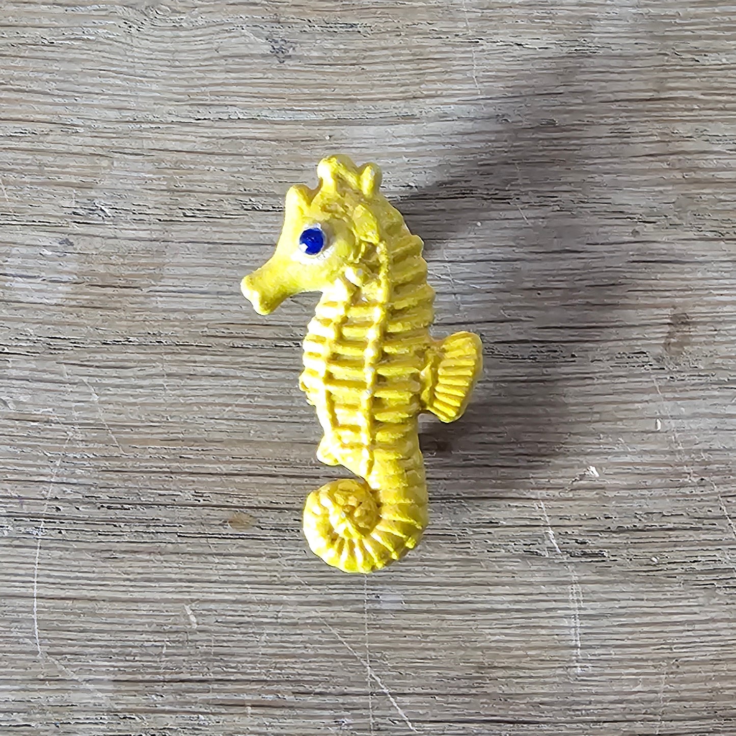 Home-made brooch using yellow celluloid seahorse with added diamante eye