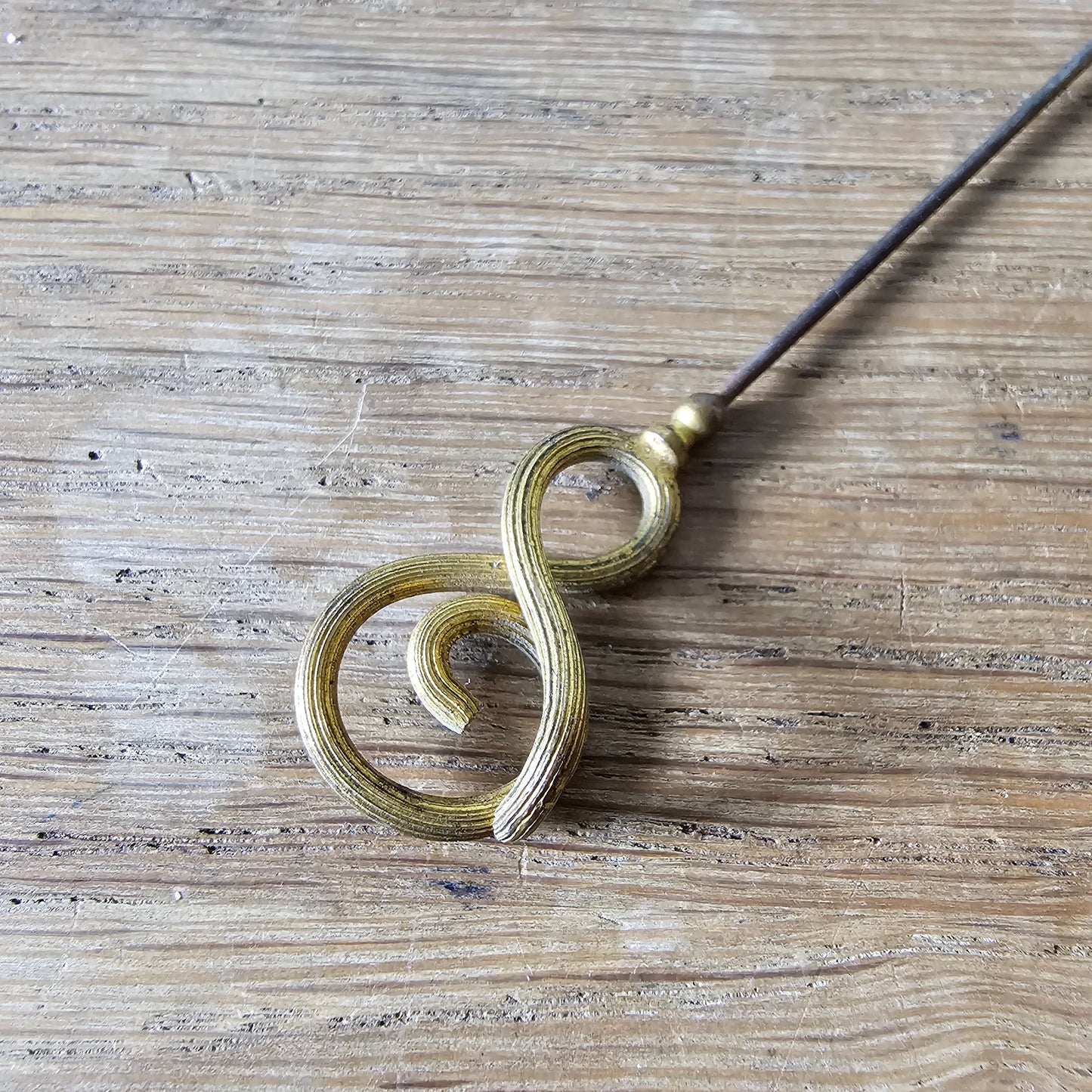 Early 20th century brass scrollwork hat pin