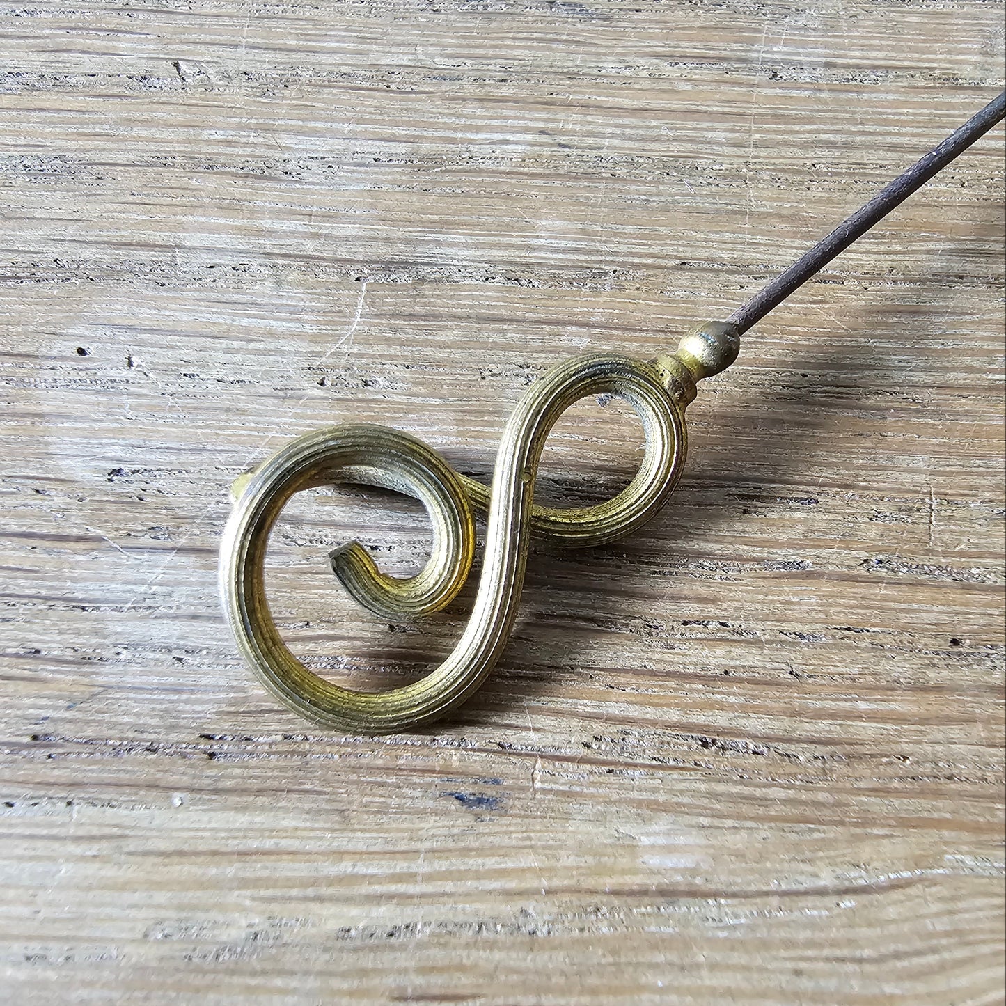 Early 20th century brass scrollwork hat pin