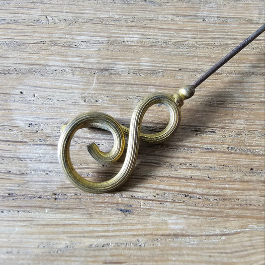 Early 20th century brass scrollwork hat pin
