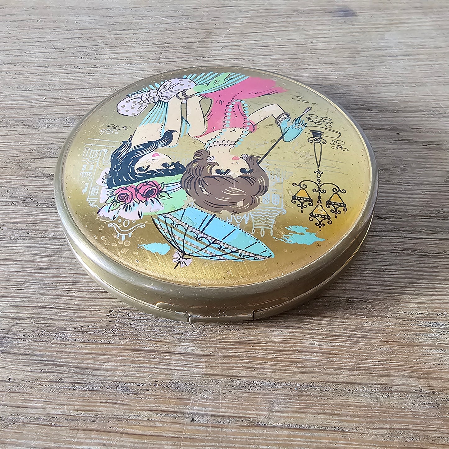 1960s gold-tone powder compact with mod fashion illustration design