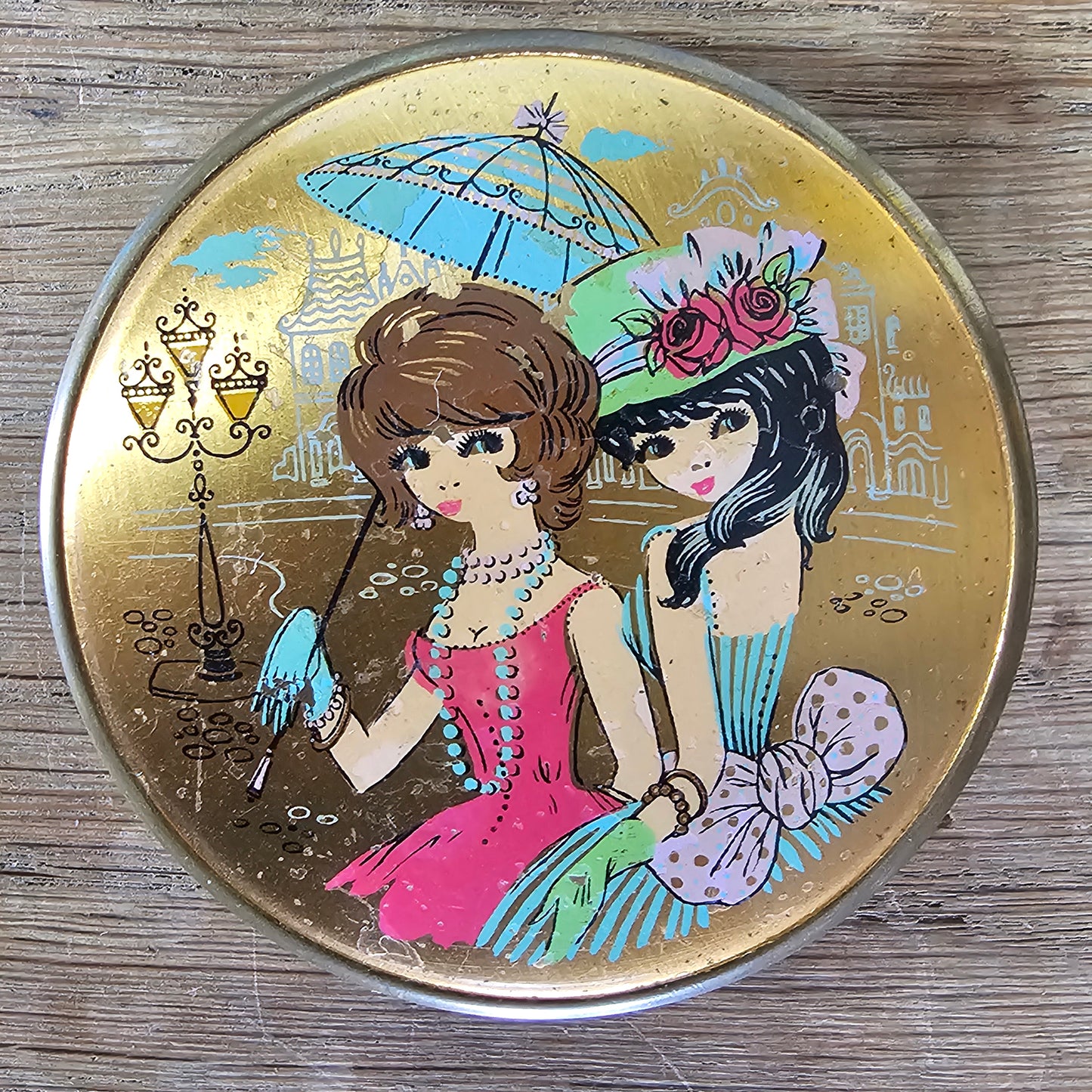 1960s gold-tone powder compact with mod fashion illustration design